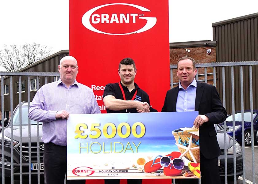 Ryan Hosking of SOS Heating is presented with his £5,000 holiday vouchers won through the Big G1 Giveaway by Andy Smith, National Sales Manager at Grant UK, right and Stewart Ratcliff, Area Sales Manager for the South West at Grant UK, left