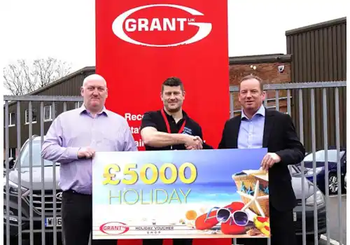 Ryan Hosking of SOS Heating is presented with his £5,000 holiday vouchers won through the Big G1 Giveaway by Andy Smith, National Sales Manager at Grant UK, right and Stewart Ratcliff, Area Sales Manager for the South West at Grant UK, left Ryan Hosking of SOS Heating is presented with his £5,000 holiday vouchers won through the Big G1 Giveaway by Andy Smith, National Sales Manager at Grant UK, right and Stewart Ratcliff, Area Sales Manager for the South West at Grant UK, left