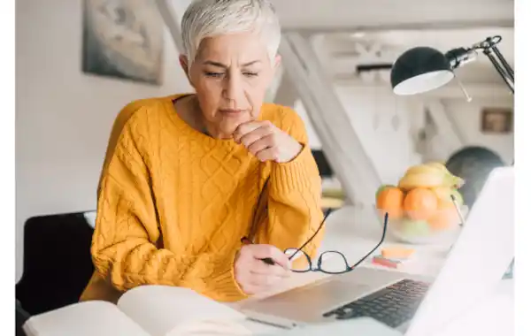 Woman using family tree software on a laptop to explore genealogy Woman using family tree software on a laptop to explore genealogy