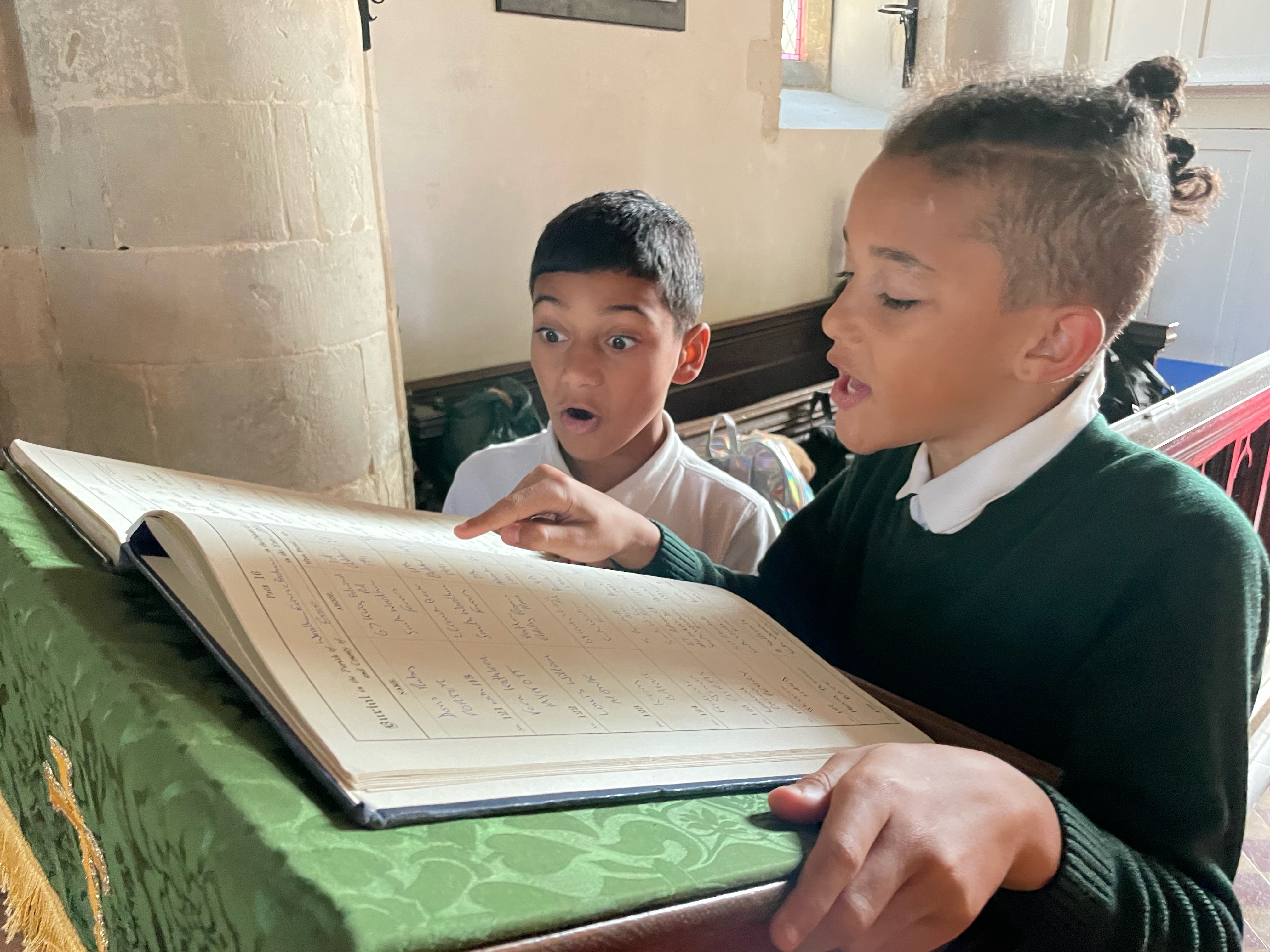 Year 5 pupils studying the burial register for St Mary's Church Woodham Ferrers Essex